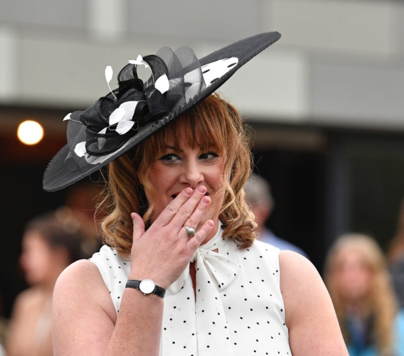 lady giggling in a fancy hat at ladies day