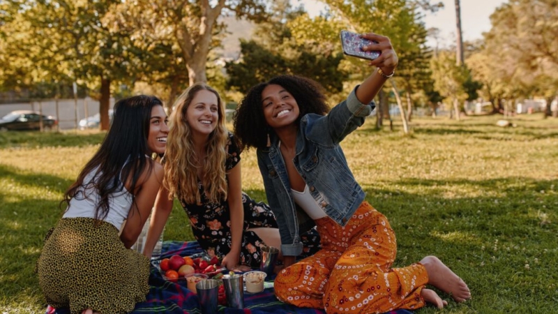 three young women having a picnic on the floor